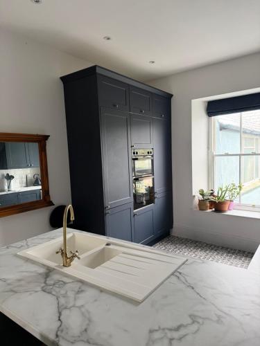 a kitchen with a sink and a blue cabinet at The Teign Rooms in Teignmouth