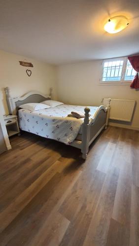 a bed in a bedroom with a wooden floor at T1 Dans Maison Au Calme in Réalmont