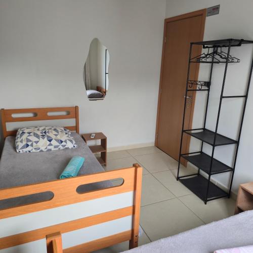a bedroom with a bed and a book shelf at Ap Lagoa da Prata com Ar condicionado in Lagoa da Prata