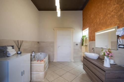 a bathroom with a tub and a sink and a bath tub at Relax House in Squinzano