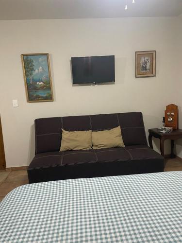 a black couch in a room with a flat screen tv at Finca El Fraile in Monterrey