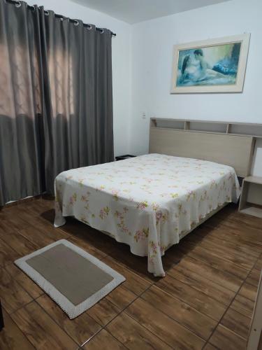 a small bed in a room with a curtain at Apt confortável in Camboriú