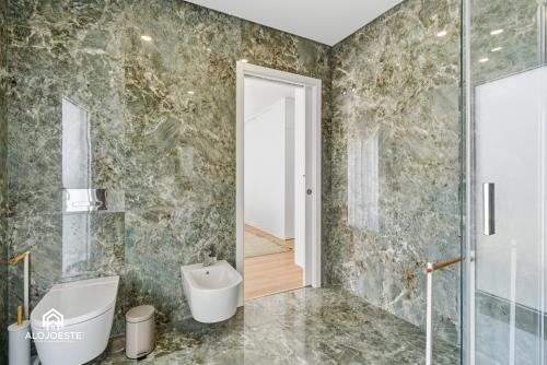 a bathroom with a toilet and a sink and a shower at Atlantic Apartments in Santa Cruz
