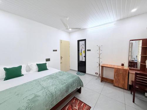 a bedroom with a large bed and a wooden desk at Hestia Homestay- 2 Bedroom Retreat Aymanam in Kottayam