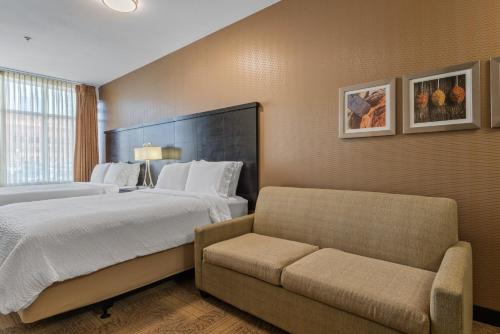 a hotel room with a bed and a couch at Staybridge Suites Denver Downtown by IHG in Denver