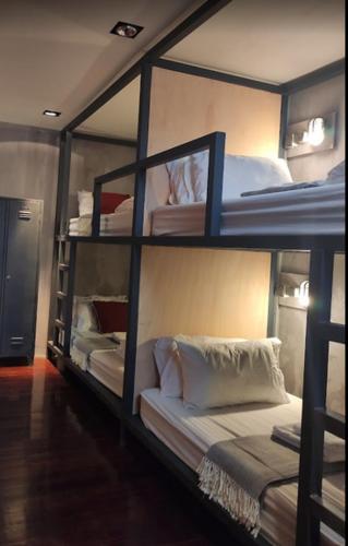 a room with three bunk beds in a room at Caruma Surf Hostel in Matosinhos
