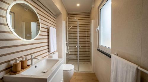 a bathroom with a white sink and a mirror at Pico Island Villas 38 - Private Atlantic Retreat in Santo António