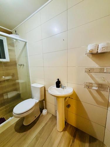 a bathroom with a toilet and a sink at Apto Rio grande com varanda e 160mt de terraço in Rio Grande