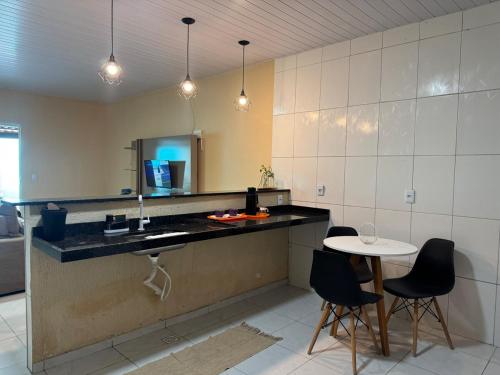a kitchen with a sink and a table and chairs at Casa Mobiliada AR02 com 3 camas e 2 quartos in Juazeiro do Norte