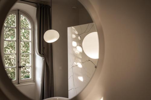 a bathroom with a mirror and a window at Couvent de la Salette & Spa in Millau