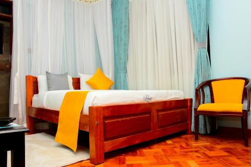 a bedroom with a bed and a yellow chair at Fahari Cedar House in Kericho