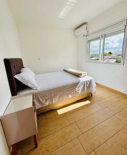 a bedroom with a bed and a window at Apto Rio grande com varanda e 160mt de terraço in Rio Grande