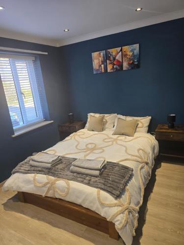 a bedroom with a large bed with blue walls at Grace's Spacious Home in Ely in Ely