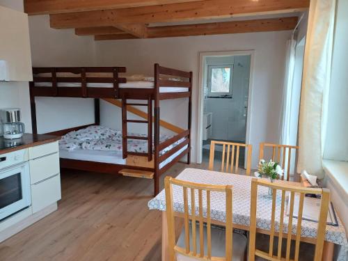a room with two bunk beds and a table and a kitchen at Ferienwohnung Maria & Luis in Kolsass
