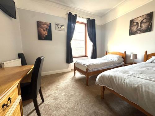 a bedroom with two beds and a desk and a window at Meze hotel in Perth
