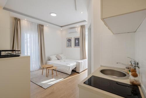 a white living room with a bed and a sink at Sea Point Apartments Igalo in Igalo