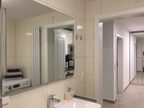 La salle de bains est pourvue d'un lavabo et d'un miroir. dans l'établissement Apartment - zentrumsnah, eigener Parkplatz und großer Balkon ins Grüne, à Baden-Baden