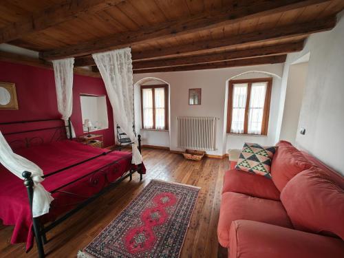 a living room with a red bed and a couch at Le Ortensie Lago di Garda in Monzambano