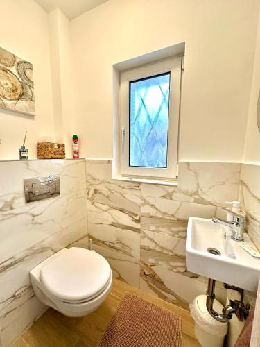a bathroom with a toilet and a sink and a window at Sunny Private Beach in Balatonlelle