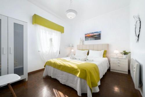 a bedroom with a bed with a yellow blanket at Casa Morais in Odeceixe