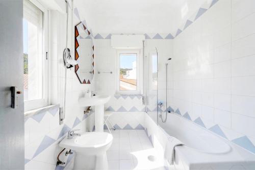 a bathroom with a sink and a tub and a toilet at Casa Morais in Odeceixe