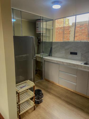 a kitchen with a stainless steel refrigerator and a sink at High Garden Apartment in Trujillo