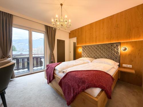 a bedroom with a large bed with a large window at Thurners Boutique Hotel at Großglockner, Film Inspired in Bruck an der Großglocknerstraße