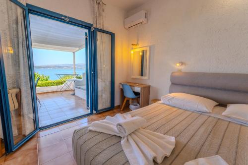 a bedroom with a bed and a view of the ocean at Metaxatos Apartments in Lassi