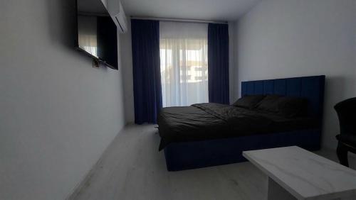 a small bedroom with a bed and a window at 85th Pool View Studio in Popeşti-Leordeni