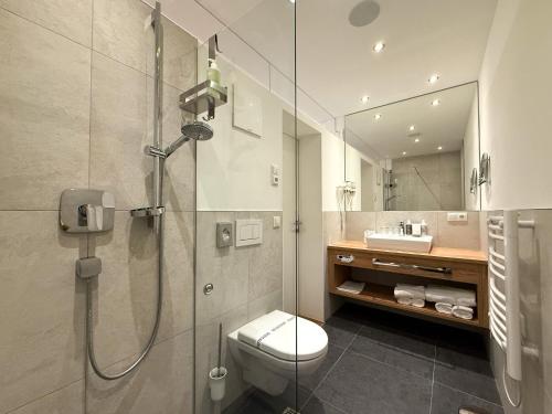 a bathroom with a shower with a toilet and a sink at Thurners Boutique Hotel at Großglockner, Film Inspired in Bruck an der Großglocknerstraße