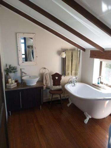 a bathroom with a large white tub and a sink at Selah Sands in Port Alfred