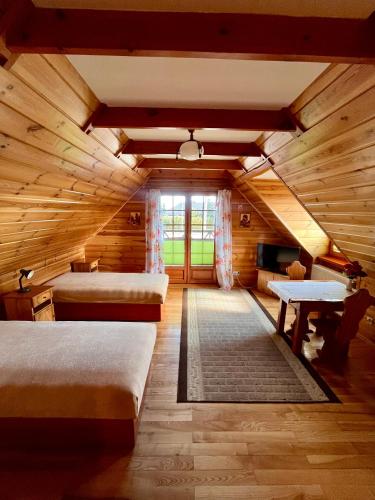 a room with two beds in a log cabin at GAMP Paweł Sawicki in Kleszczele