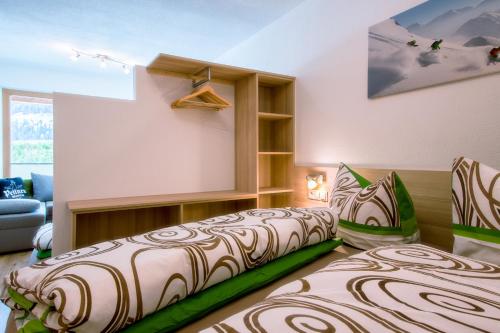 a bedroom with two beds and a couch at Apart Mirjam in Pettneu am Arlberg