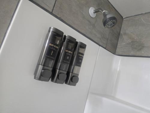 a set of three bottles of shampoo sitting on a bathroom door at Comfortable Stay Evanston NW - Near YYC Airport, Highways, Shopping & Parks in Calgary