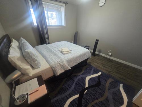 a small bedroom with a bed and a window at Comfortable Stay Evanston NW - Near YYC Airport, Highways, Shopping & Parks in Calgary