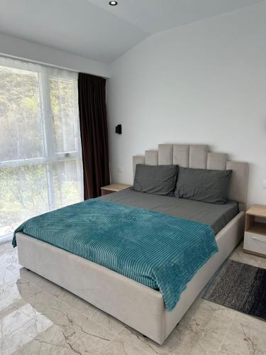 a large bed in a bedroom with a large window at guest house Qyteza in Shkodër