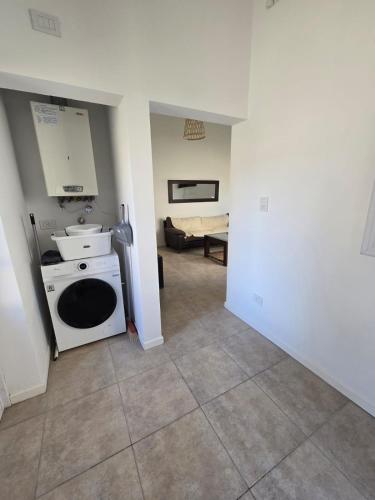 a kitchen with a stove and a sink in a room at Casita Cómoda y Acogedora in Trenque Lauquen