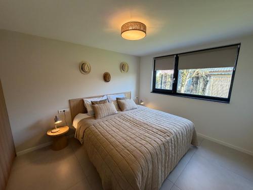 a bedroom with a bed and a window at Vakantiehuis Lucky in Ons Belang