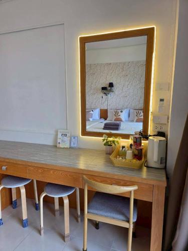 a room with a desk with a mirror and a bed at the stay bangsaen in Ban Rong Khoei