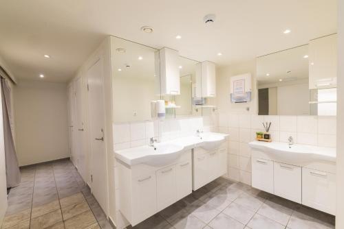 a bathroom with two sinks and two mirrors at Hostel Fjordur in Hafnarfjörður