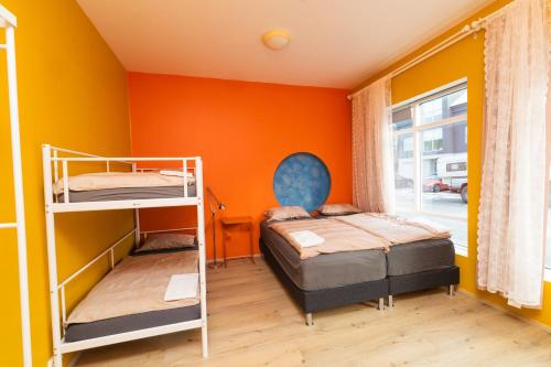 two bunk beds in a room with orange walls at Hostel Fjordur in Hafnarfjörður