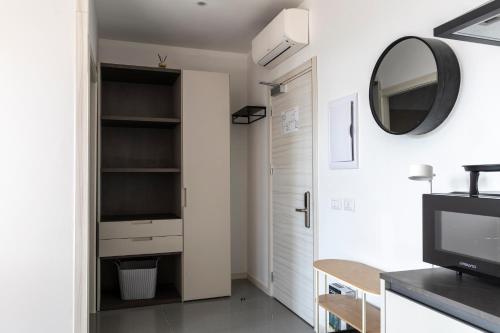 a living room with a television and a mirror at Foresteria SMART ROOMS in Viadana