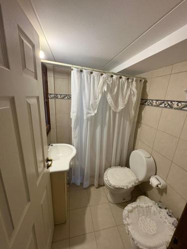 a white bathroom with a toilet and a sink at Rincón del Cielo Country Club in Merlo