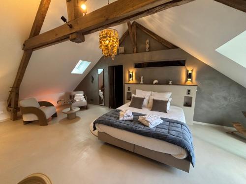 ein Schlafzimmer mit einem großen Bett im Dachgeschoss in der Unterkunft Lintemporel in Cuzance