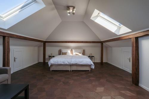 a attic bedroom with a bed and skylights at The One Wadowice in Wadowice