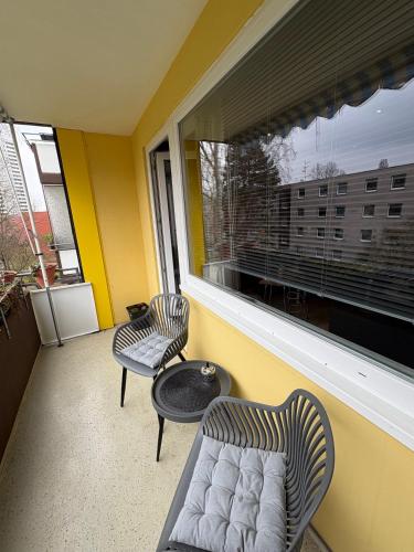 ein Balkon mit zwei Stühlen, einer Couch und einem Fenster in der Unterkunft Tiny Timeout in Braunschweig
