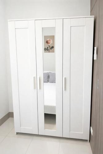 a wardrobe with white doors in a room at Casa MJ Suites at SMDC Fame Residences, Mandaluyong in Manila