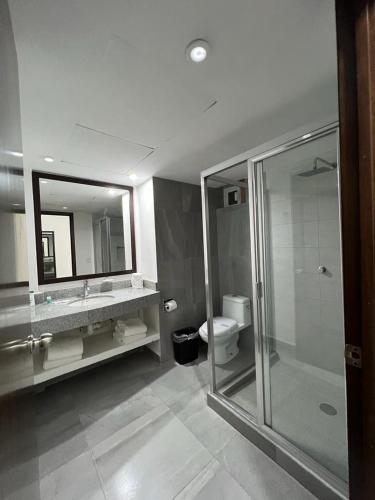 a bathroom with a shower and a sink and a toilet at Solamar Inn Mazatlan in Mazatlán