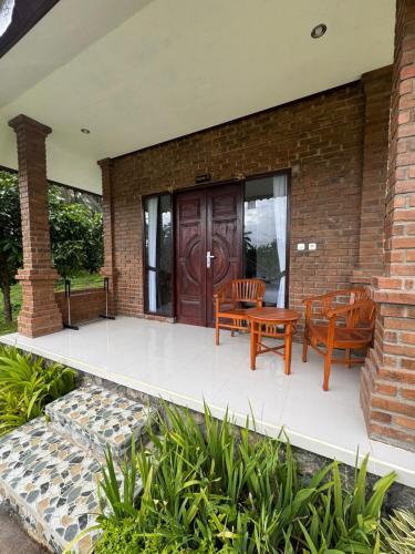 a patio with two chairs and a wooden door at Indra Yoga Retreat in Selemadeg