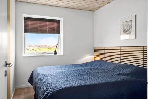 a bedroom with a blue bed and a window at 705-Thyboron-Romovej-7 in Thyborøn